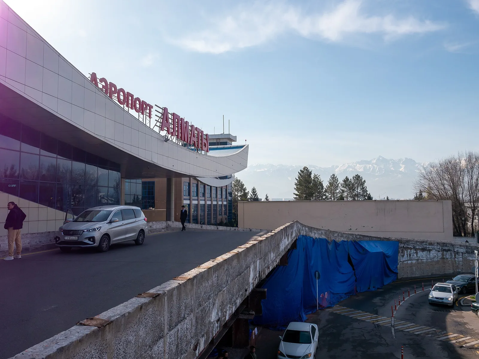 Сәуірдің басындағы Алматы әуежайы: ішкі терминал, көктемгі ағаштар және қала сыртындағы жотадағы қар. Фото: Matti Blume, 2024, CC BY-SA 4.0 лицензиясы, Wikimedia Commons