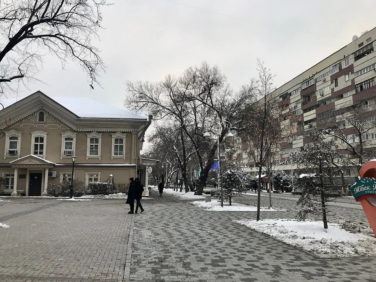 Арбат, конец ноября 2022 года: мокрая плитка, голые деревья, двухэтажный дом с резными наличниками и редкие прохожие в капюшонах. В такую погоду улица принадлежит тем, кто вышел. Фото: ShadZ01, Wikimedia Commons, CC BY 4.0