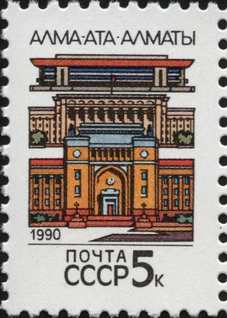 Марка Почты СССР, 1990 год: «Алма-Ата — Алматы», три здания одно над другим — внизу Академия наук с аркой-пештаком, выше Дом правительства и Дворец Республики. За пять копеек на конверте ехала через всю страну та самая арка, у которой мы стоим. Марка Почты СССР, 1990, Wikimedia Commons, общественное достояние